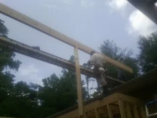 Carpenter setting a ridge beam over a new addition frame — Ice Dam Removal by Roofing Brothers in Country Club Hills