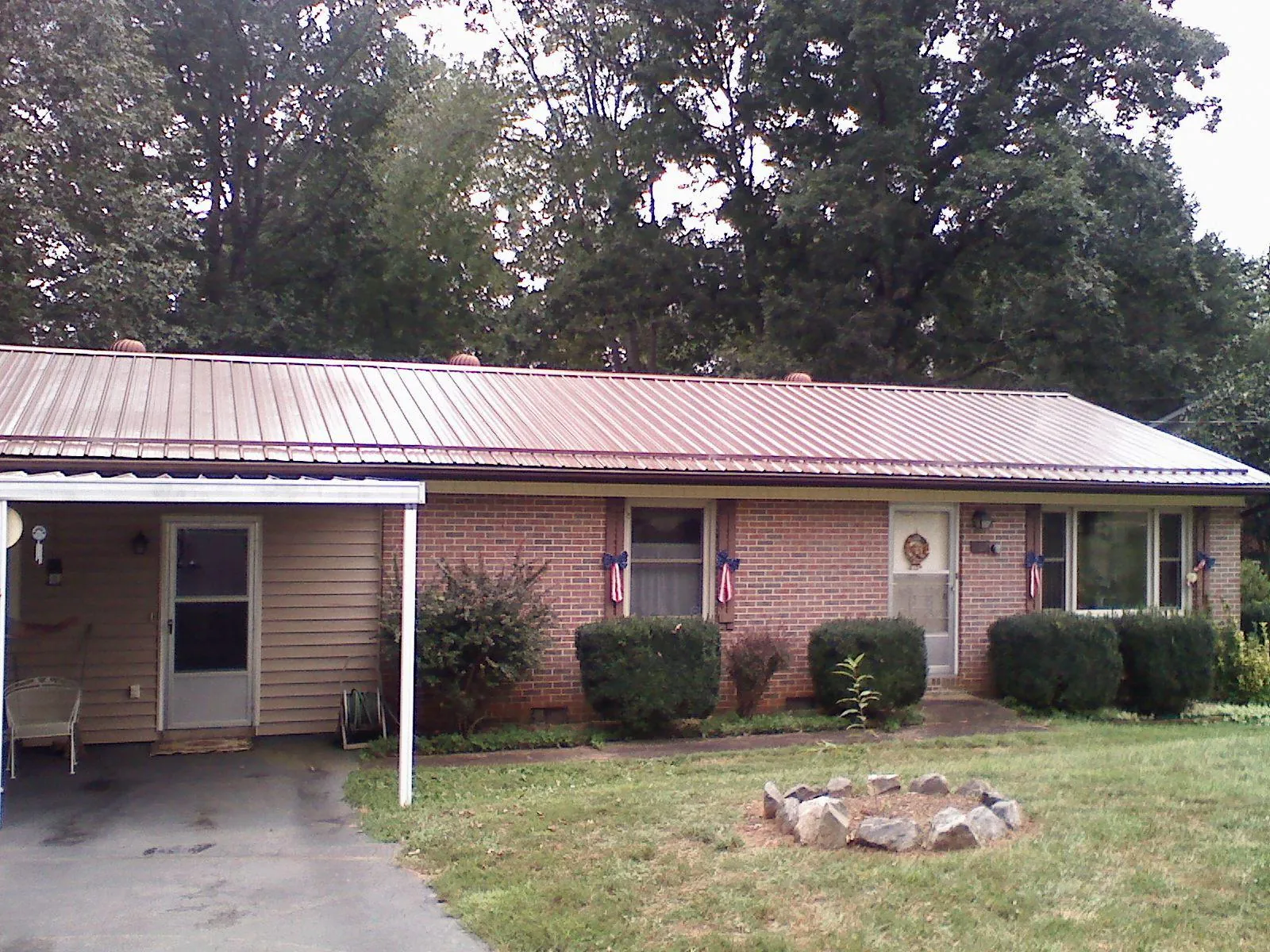 Bronze metal roof and carport on a brick ranch home — Roof Repair work by our crew in Country Club Hills